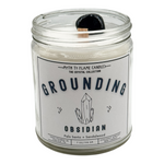 Candle jar labeled 'Grounding Obsidian' with a crystal design on a white background