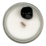 Candle in a glass jar with a black lid on a white background